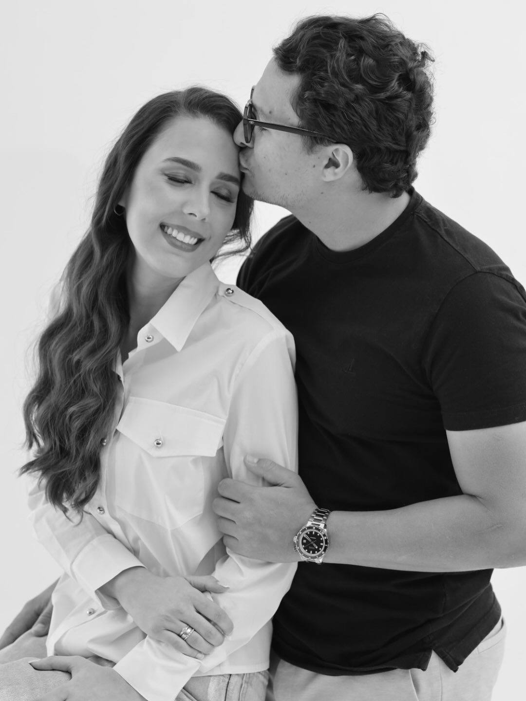 Casal em estúdio, ele beijando a testa dela