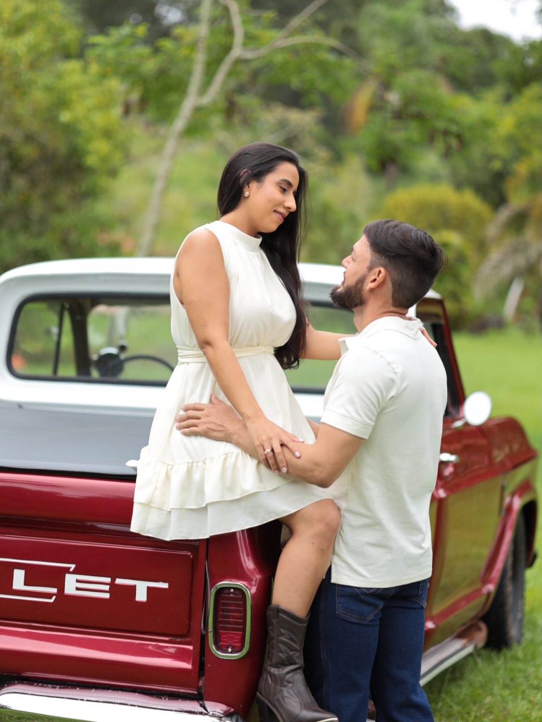 Casal ao ar livre apoiado em uma picape vintage